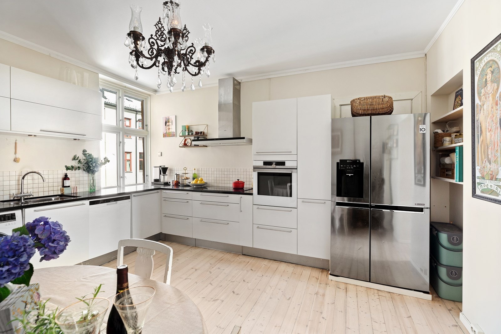 Sort benkeplate i sten. Induksjonstoppen fra Siemens er ny i år. Bak kjøleskapet er dør til entréen dersom man ønsker å endre adkomst til kjøkkenet Galleribilde