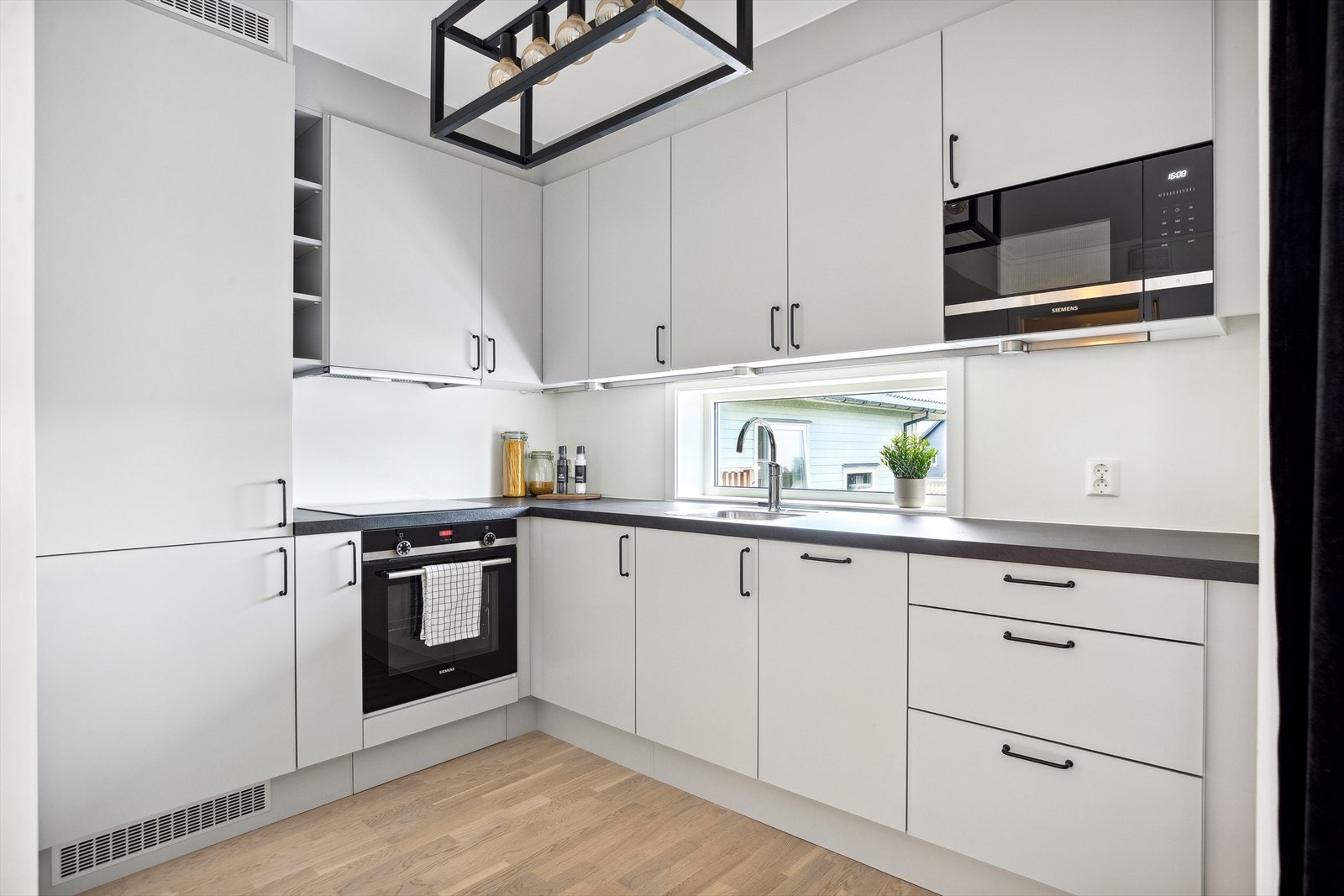 Kjøkkenet har et moderne design med takoppforede skap og benkeplater av laminat. Galleribilde