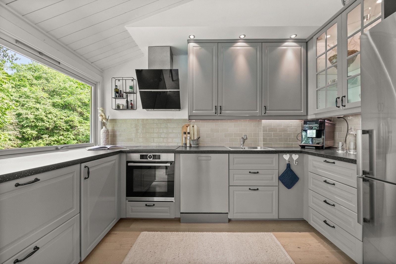 Innholdsrikt kjøkken med profilerte fronter og laminat benkeplate. Galleribilde