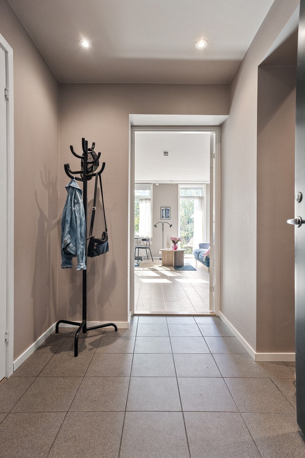 Romslig entré med fliser på gulv og downlight i himling Galleribilde