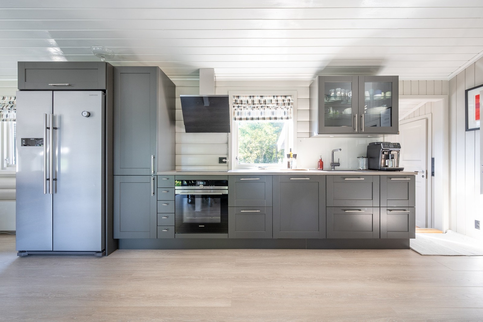 Kjøkkenet er designet med en tidløs estetikk, med grå skapfronter og benkeplate av lys laminat. Galleribilde