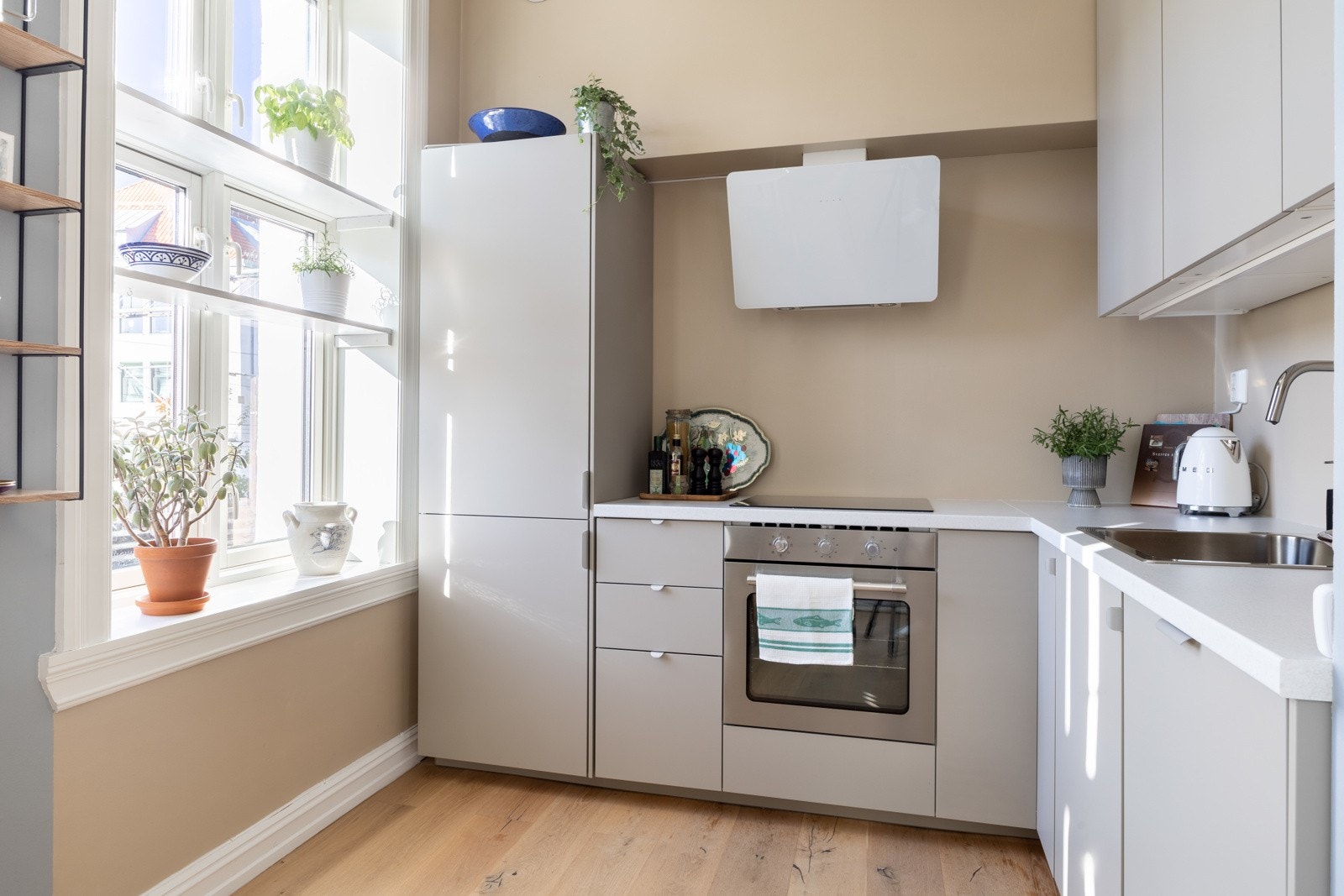 Den moderne kjøkkenet er fra 2024 med nye hvitevarer, glatte fronter og benkeplater av laminat. Galleribilde