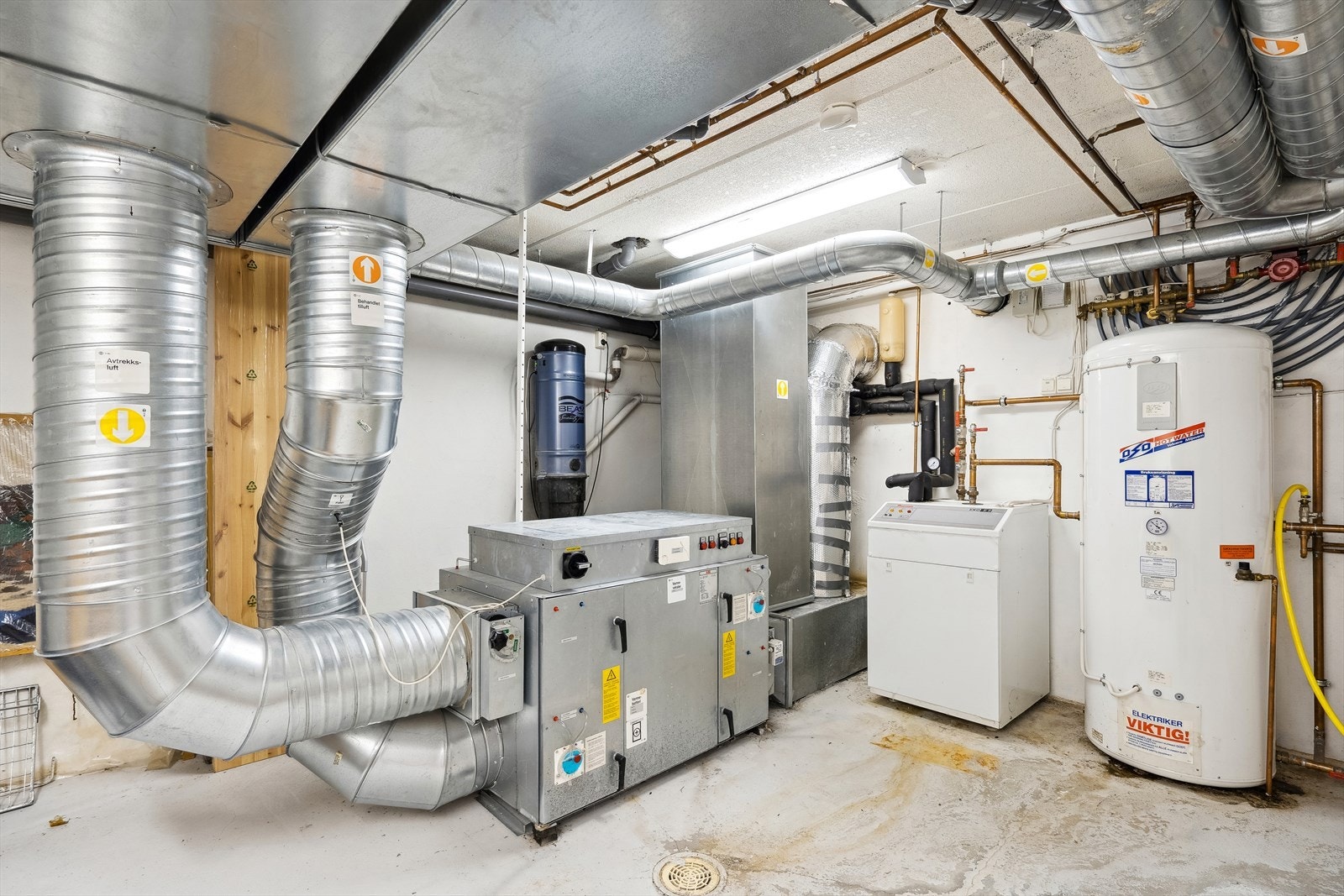 På det tekniske rommet i kjelleren finnes bl.a. aggregatet til ventilasjonssystemet, væske/vann varmepumpe, stoppekran og og sentralstøvsuger . Galleribilde