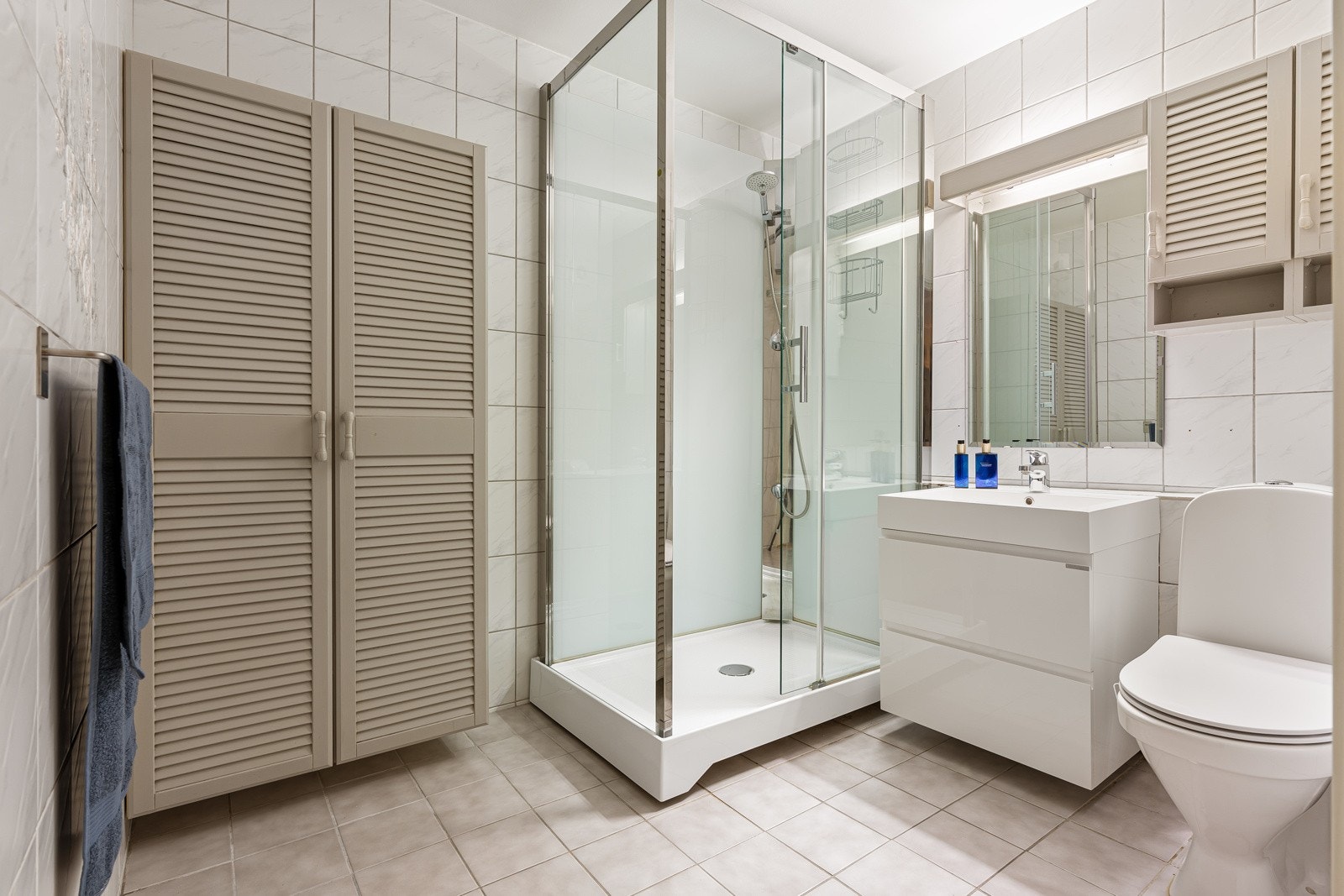 Badet er innredet med dusjkabinett, servant, speil, belysning og gode oppbevaringsmuligheter for toalettartikler. Galleribilde