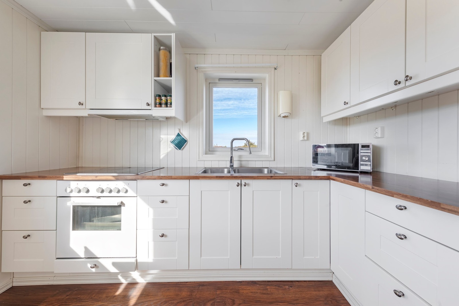 Kjøkkenet har lys innredning med profilerte fronter og laminert benkeplate Galleribilde