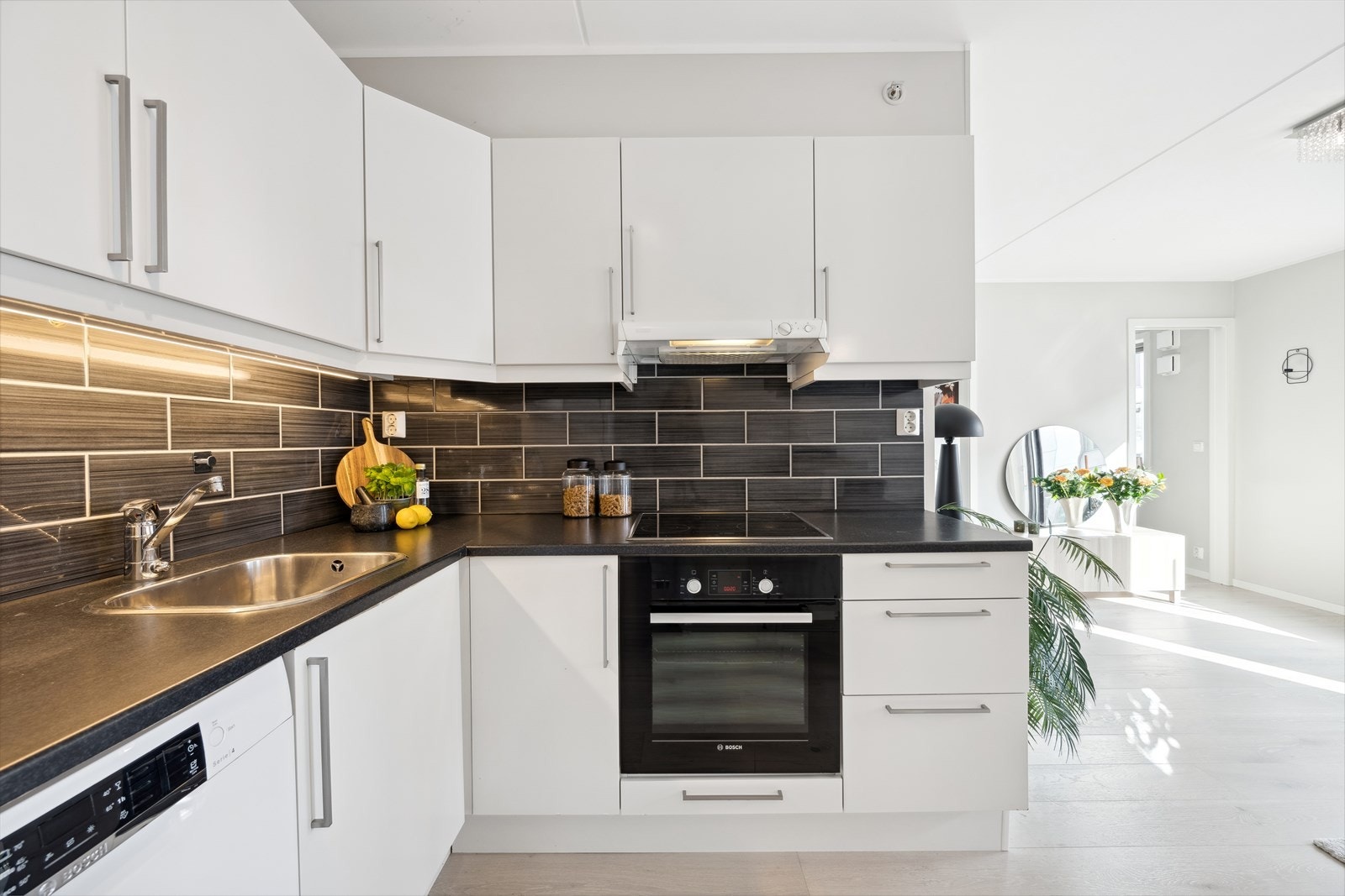 Kjøkkeninnredningen er i praktisk L-form og det er montert fliser mellom benk og skap. Galleribilde