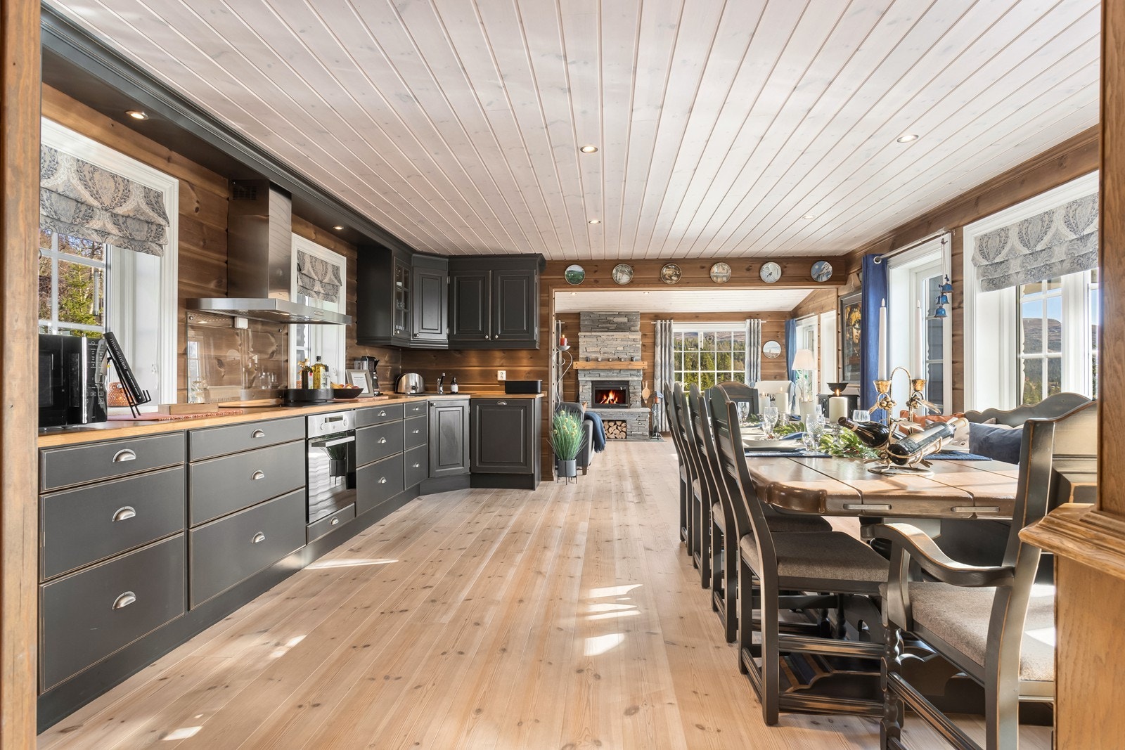 Kjøkkenet byr på en praktisk utforming med mye benkeplass, mørke profilerte fronter og heltre benkeplate. Galleribilde