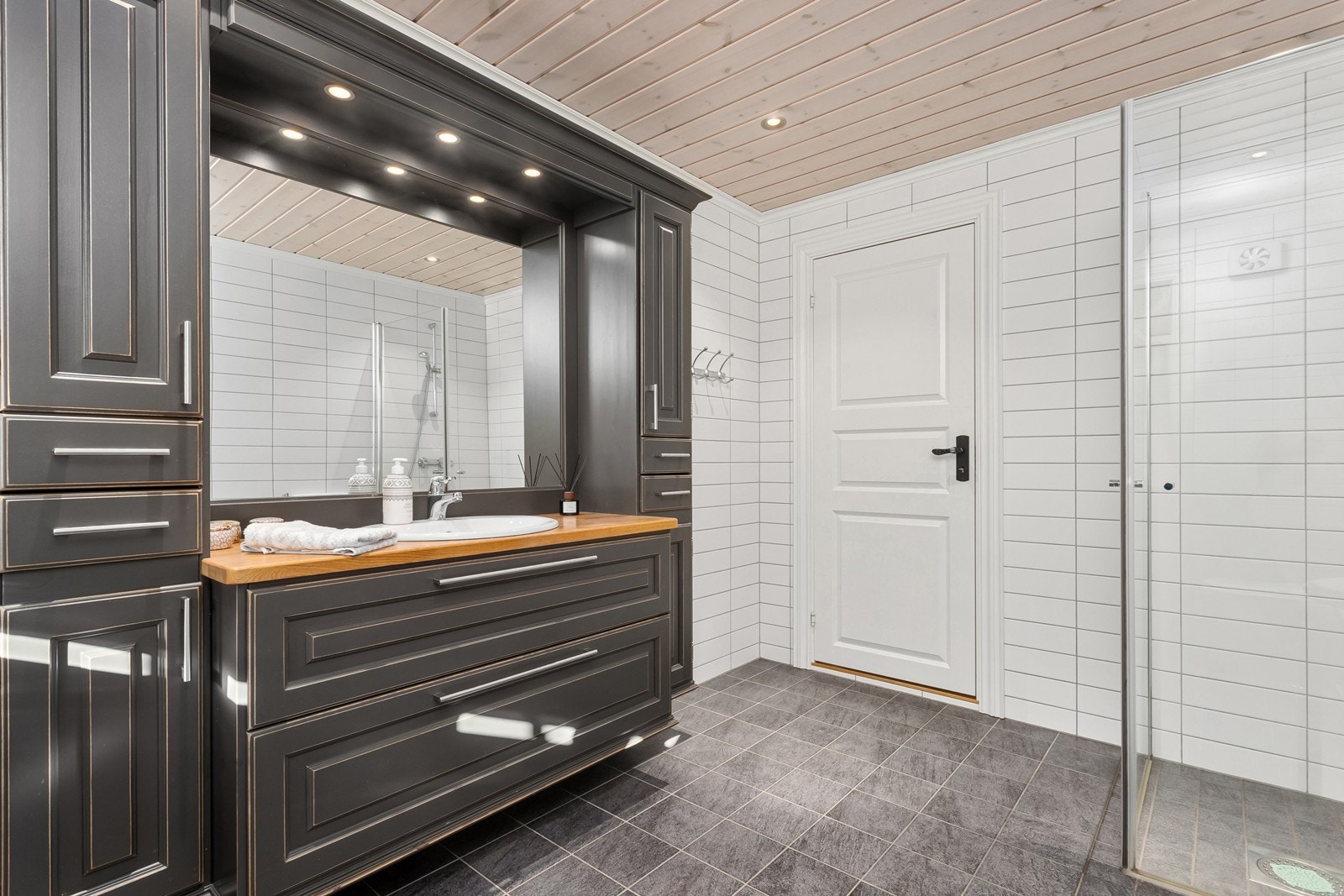 Badet er innredet med en lekker og eksklusiv servantløsning med god plass til diverse oppbevaring og speil Galleribilde