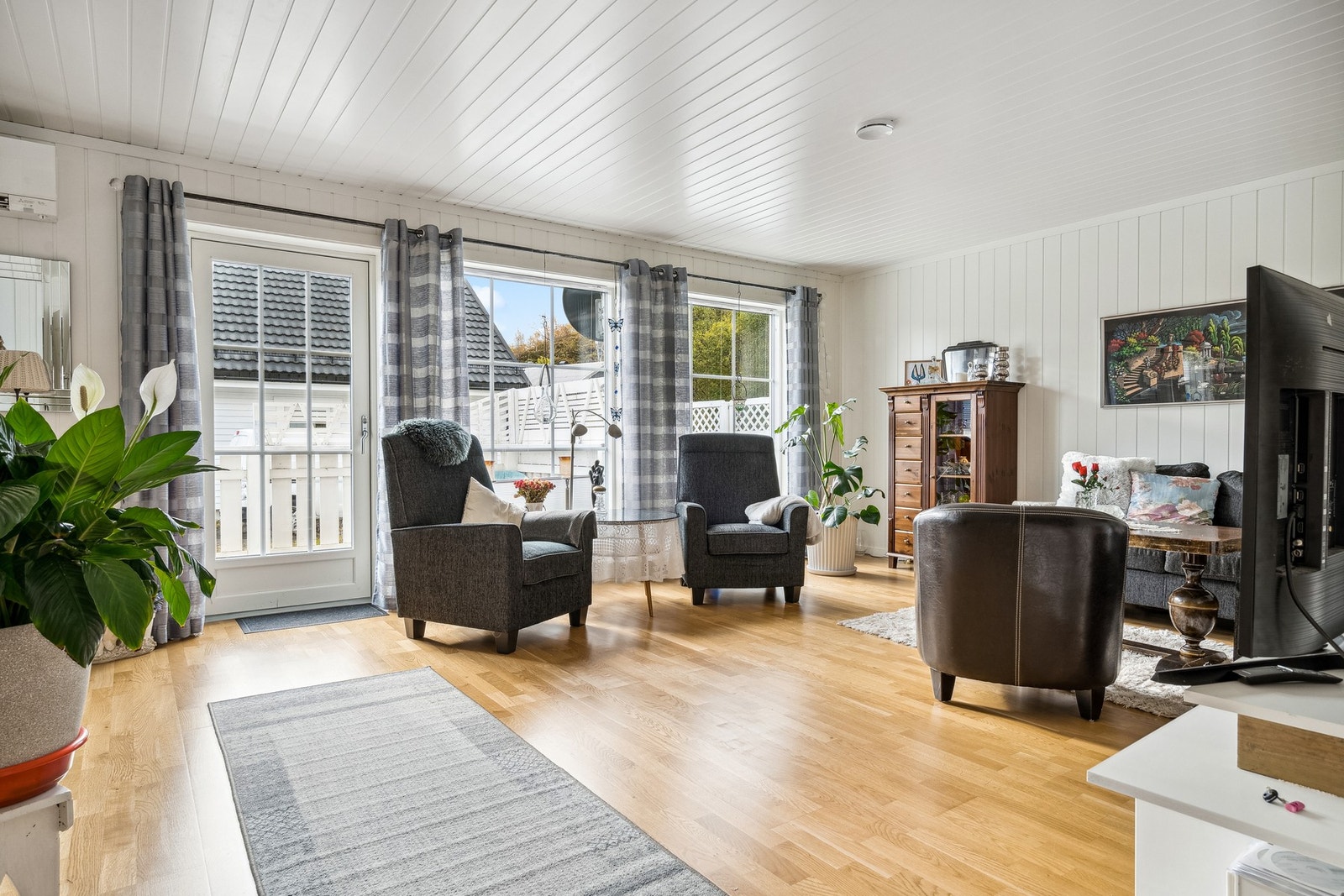 Romslig stue med store vindusflater i front som slipper inn rikelig med dagslys og skaper en god atmosfære. Galleribilde