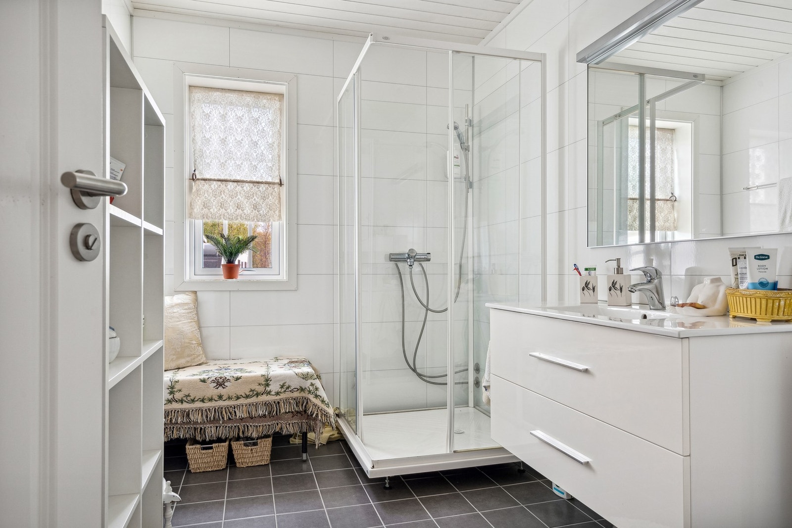 Badet er utstyrt med servant i møbel, toalett og dusjkabinett. Galleribilde