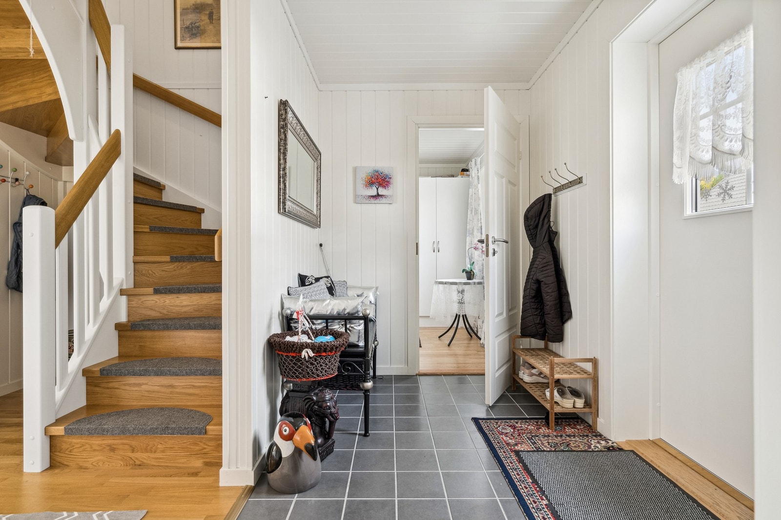 Flislagt entré med oppheng av yttertøy og skohylle. Galleribilde