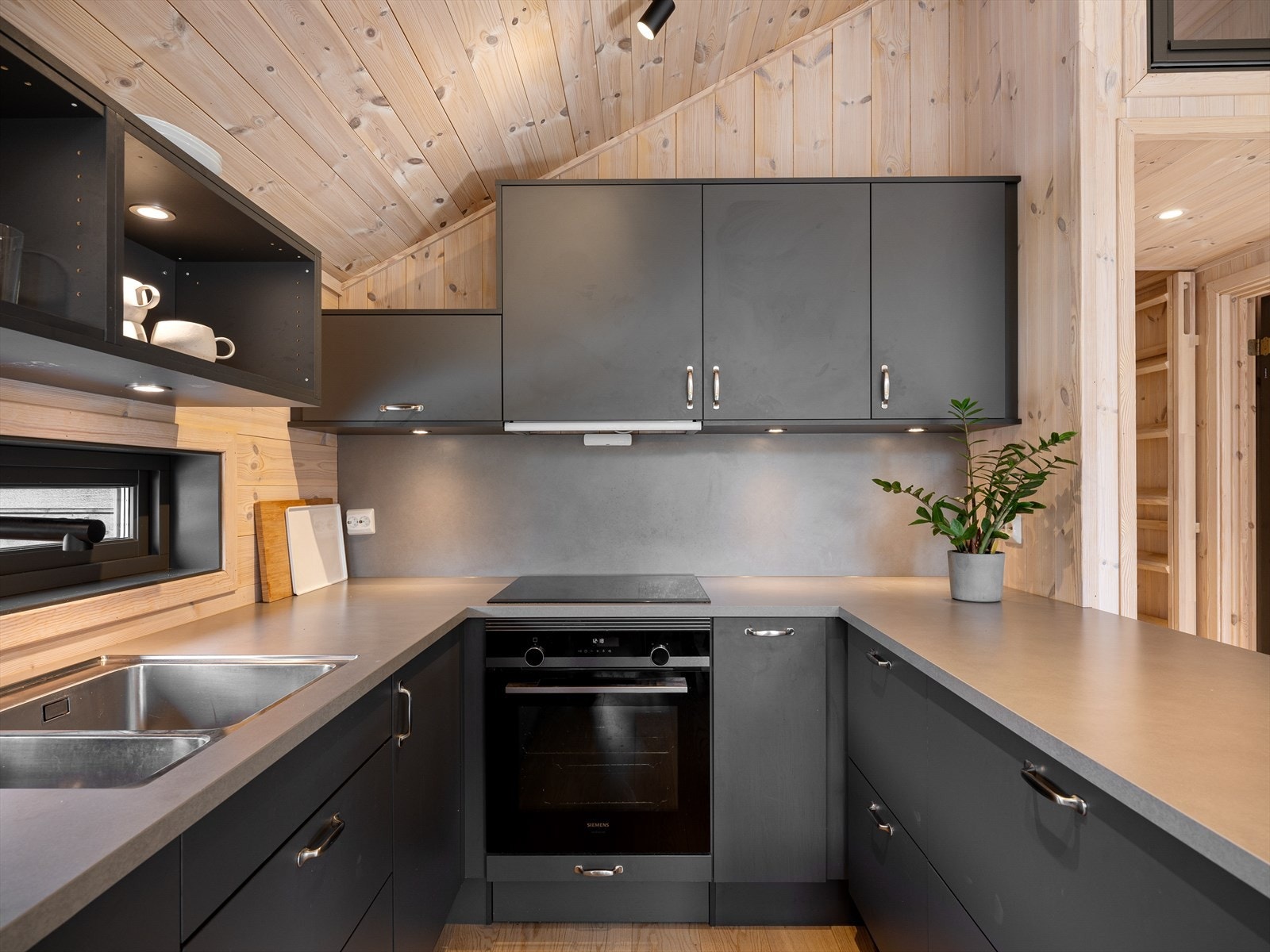 God lagringsplass i skuffer og skap. Naturlig lys inn fra vindu over vask. Galleribilde