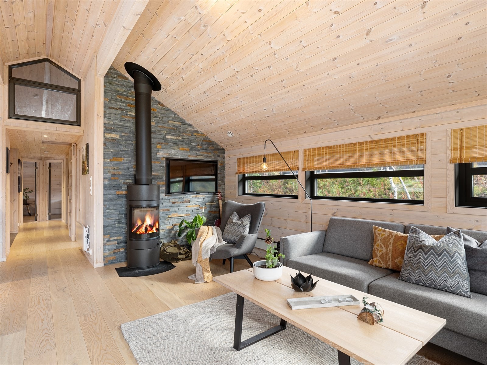 Flott steinvegg i bakkant av vedovn setter særpreg på rommet. Galleribilde