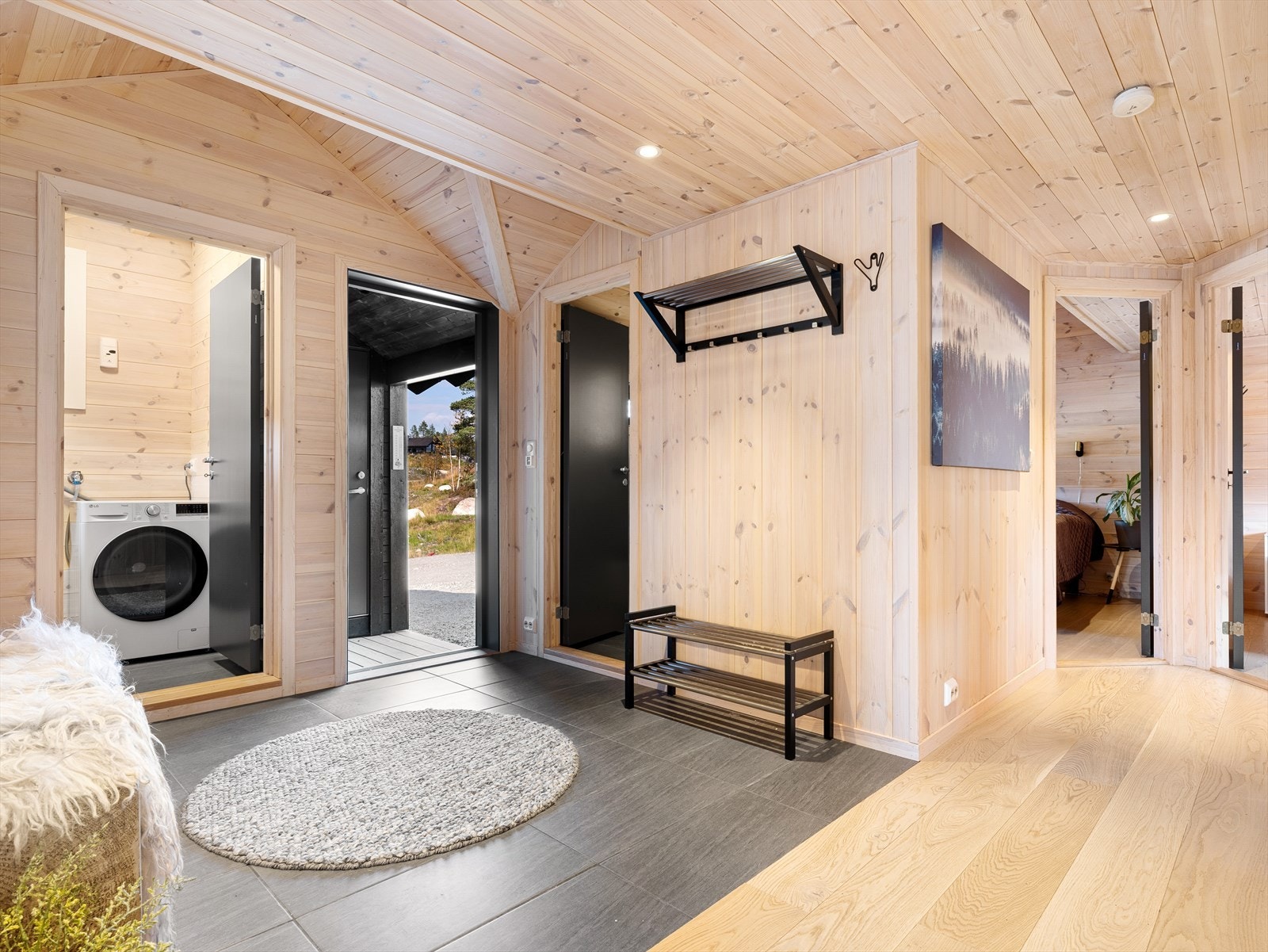 Overbygget inngangsparti med adkomst til bod.
Entre/gang med fliser på gulv. Garderobeløsning. Galleribilde