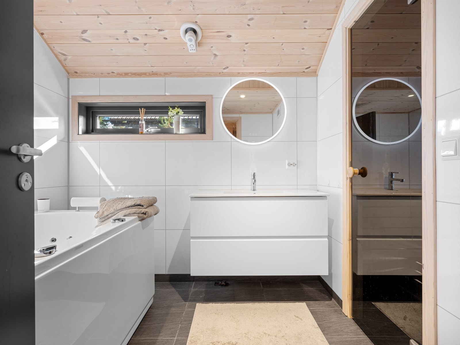 Spa avdeling med badkar, wc og vask i seksjon og speil med belysning, adkomst til badstue. Galleribilde