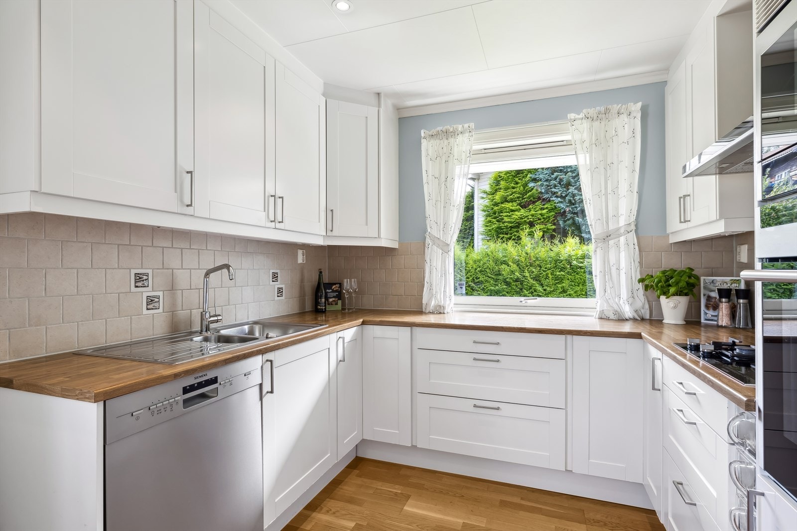 Kjøkkenet har innredning fra kvalitetsleverandør og har innredning med glatte, fabrikklakkerte fronter og laminat benkeplate med nedfelt kum i rustfritt stål. Galleribilde