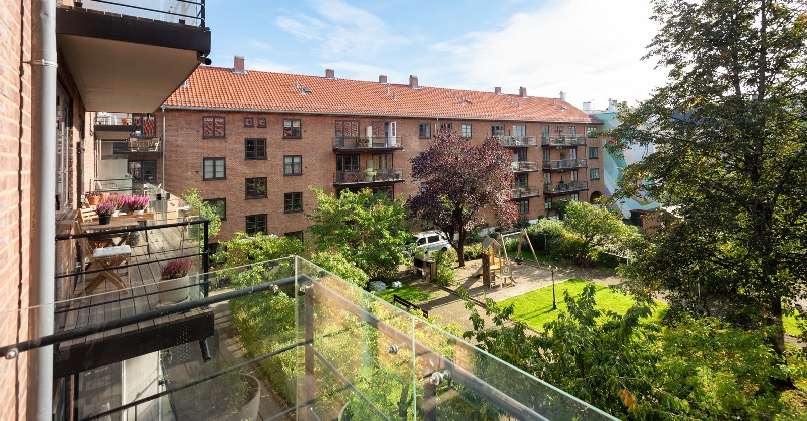 Hyggelig utsyn over borettslagets grønne og frodige gårdsrom fra kjøkkenbalkong Galleribilde