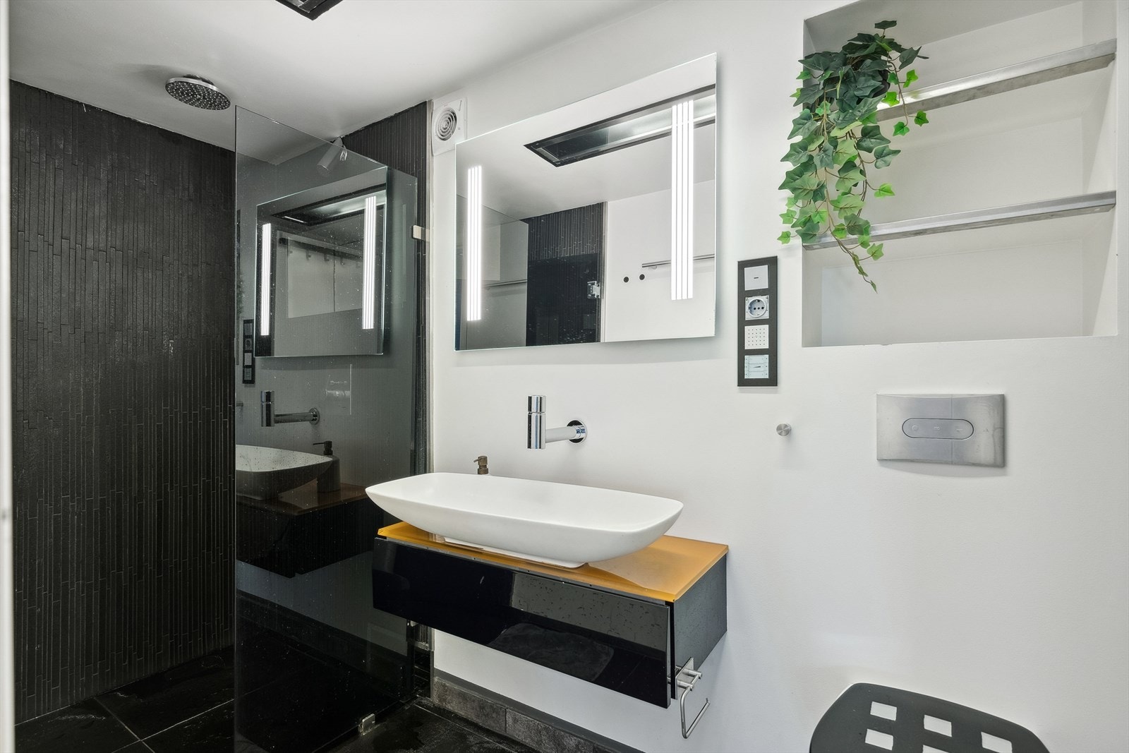 Lekkert bad med varme i gulv. Tidløs og luksuriøs design med mørke fliser på gulv og lyse fliser/malte plater på vegger. Galleribilde