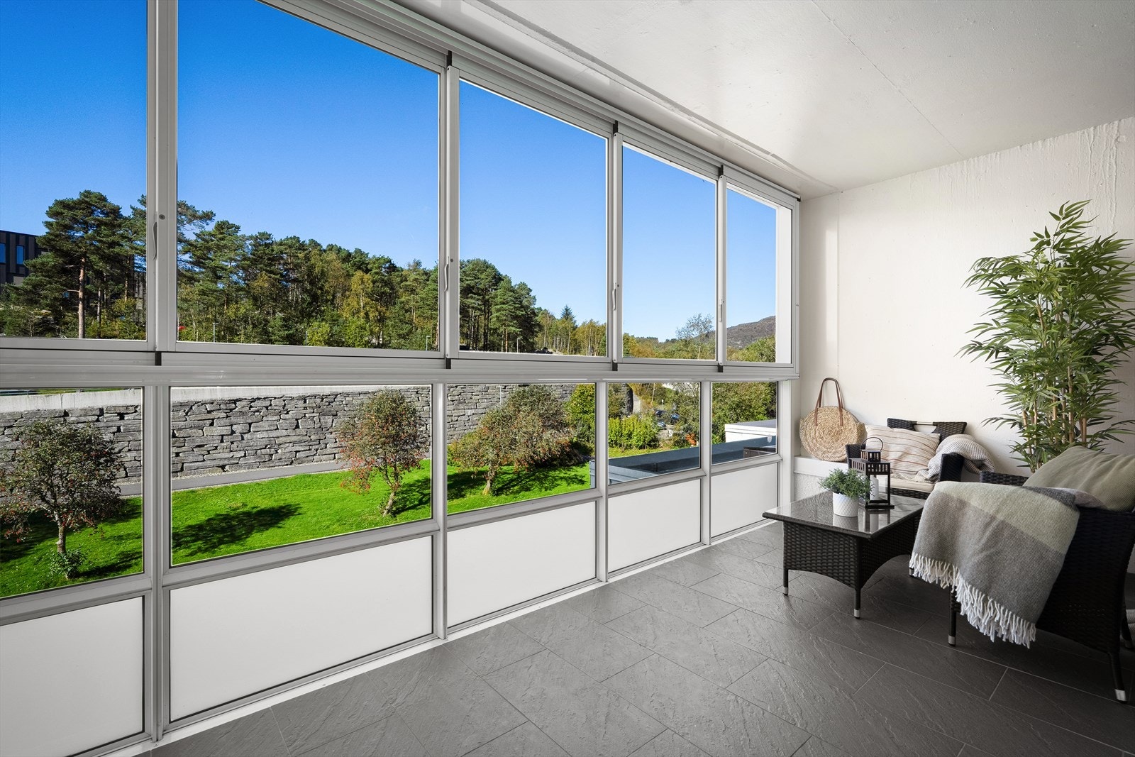 Fra stuen kommer man ut i innglasset altan. De øverste glassene kan åpnes og skyves til siden Galleribilde