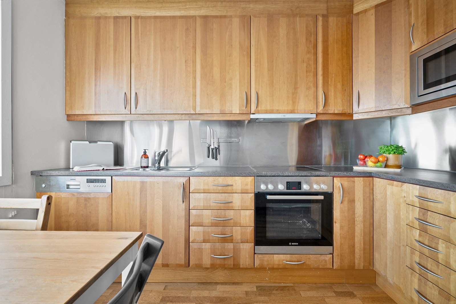 Kjøkkenet har takhøy innredning og integrerte hvitevarer Galleribilde