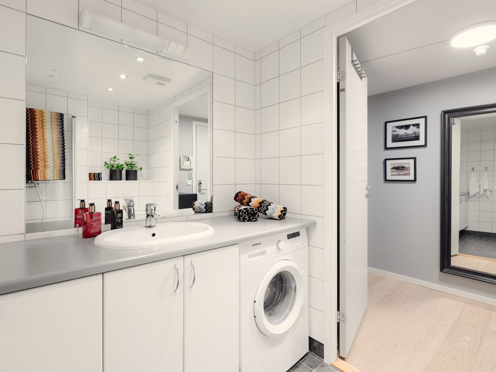 Benkeplate fra vegg til vegg med opplegg for vaskemaskin under gir et fint og helhetlig inntrykk. Galleribilde