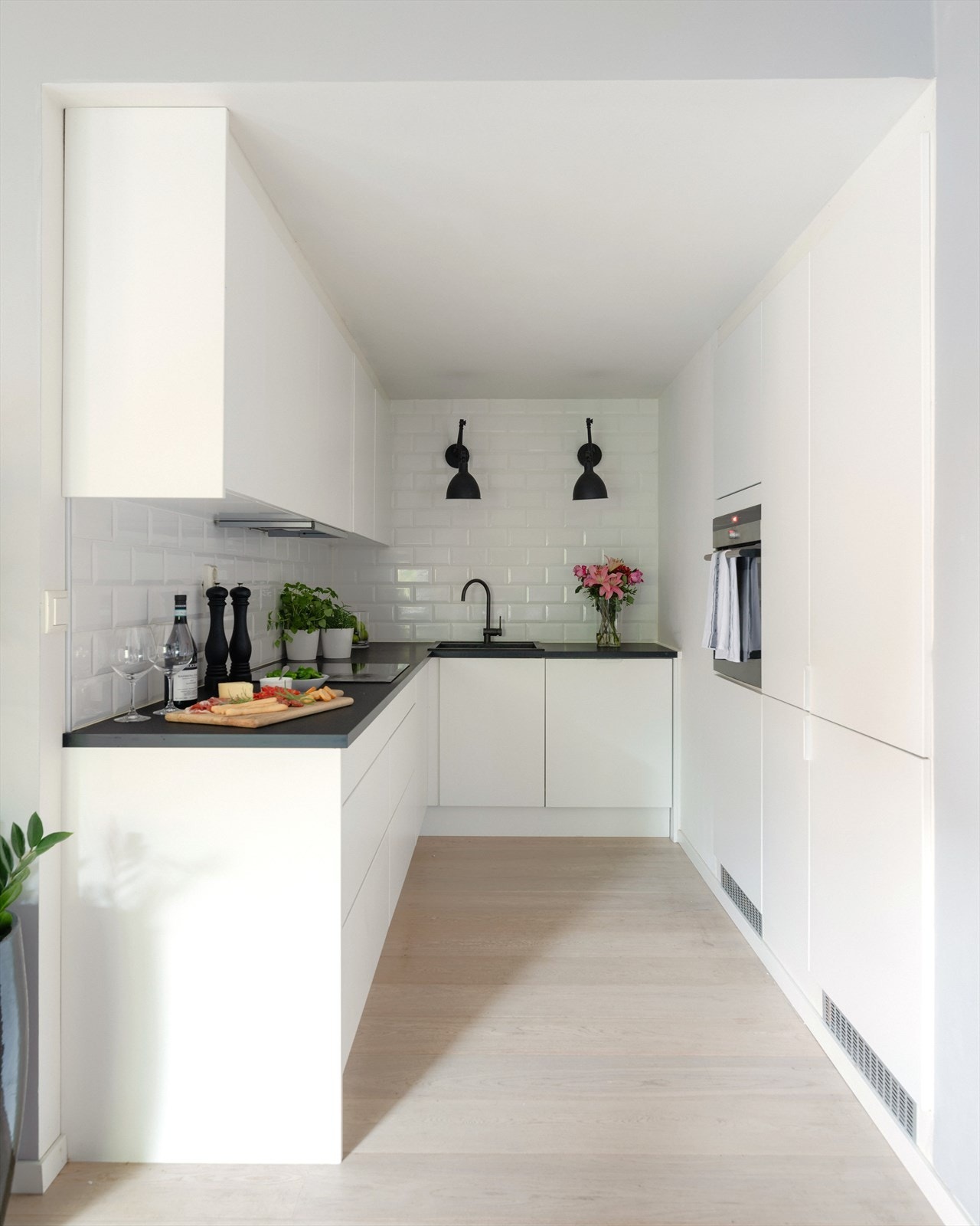 Lekkert, tidløst og praktisk kjøkken fra Designa kjøkken med laminat benkeplate. Integrert komfyr med induksjons platetopp, oppvaskmaskin og kjøl/frys. Galleribilde