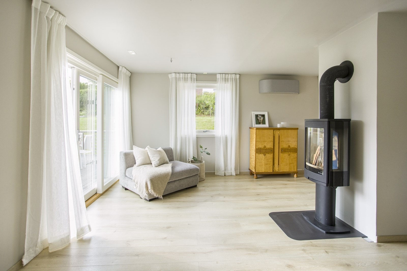 Luft-luft varmepumpe fra 2023 og peisovn plassert i stue. Galleribilde