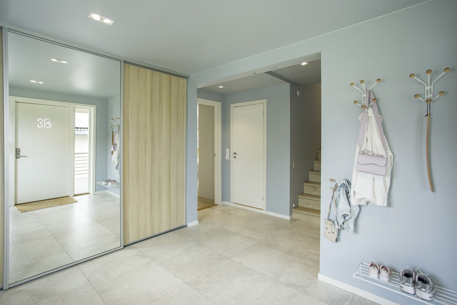 Montert skyvedørsgarderobe med god plass for oppbevaring, samt knagger og skohylle på vegg. Galleribilde