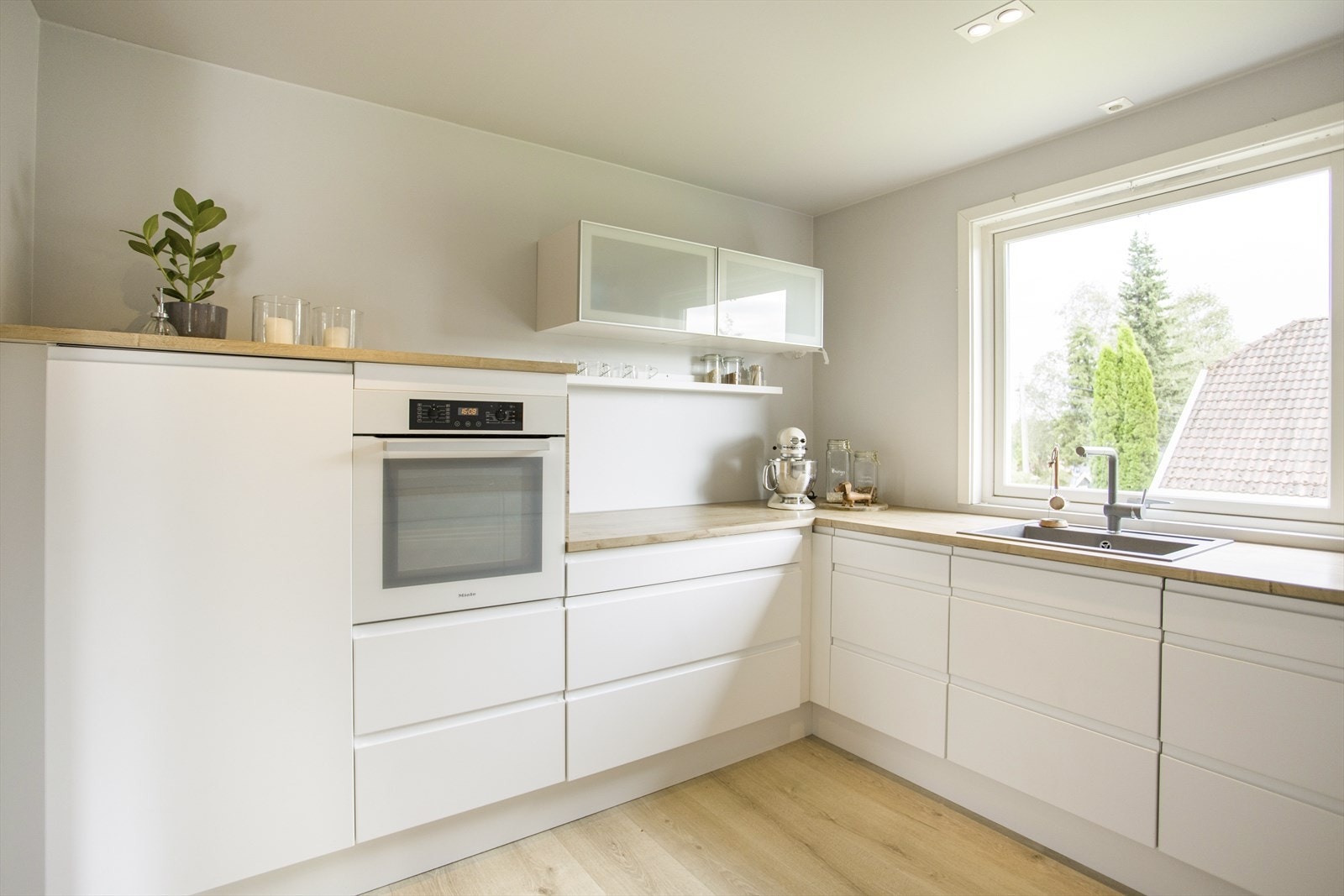 Kjøkkenet er innredet med laminert benkeplate med kjøkkenkum, integrert koketopp/komfyr, oppvaskmaskin og kjøleskap. Galleribilde