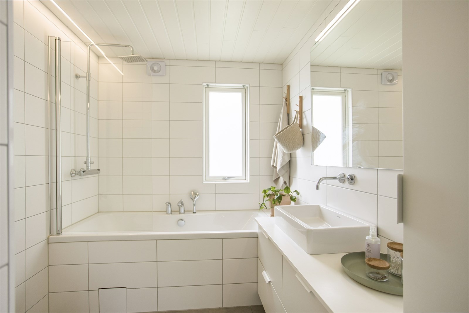 Lyst og moderne bad i første etasje renovert i 2013. Baderommet er innredet med servant med underskap, speil med tilhørende belysning, dusjkabinett og veggmontert toalett. Galleribilde