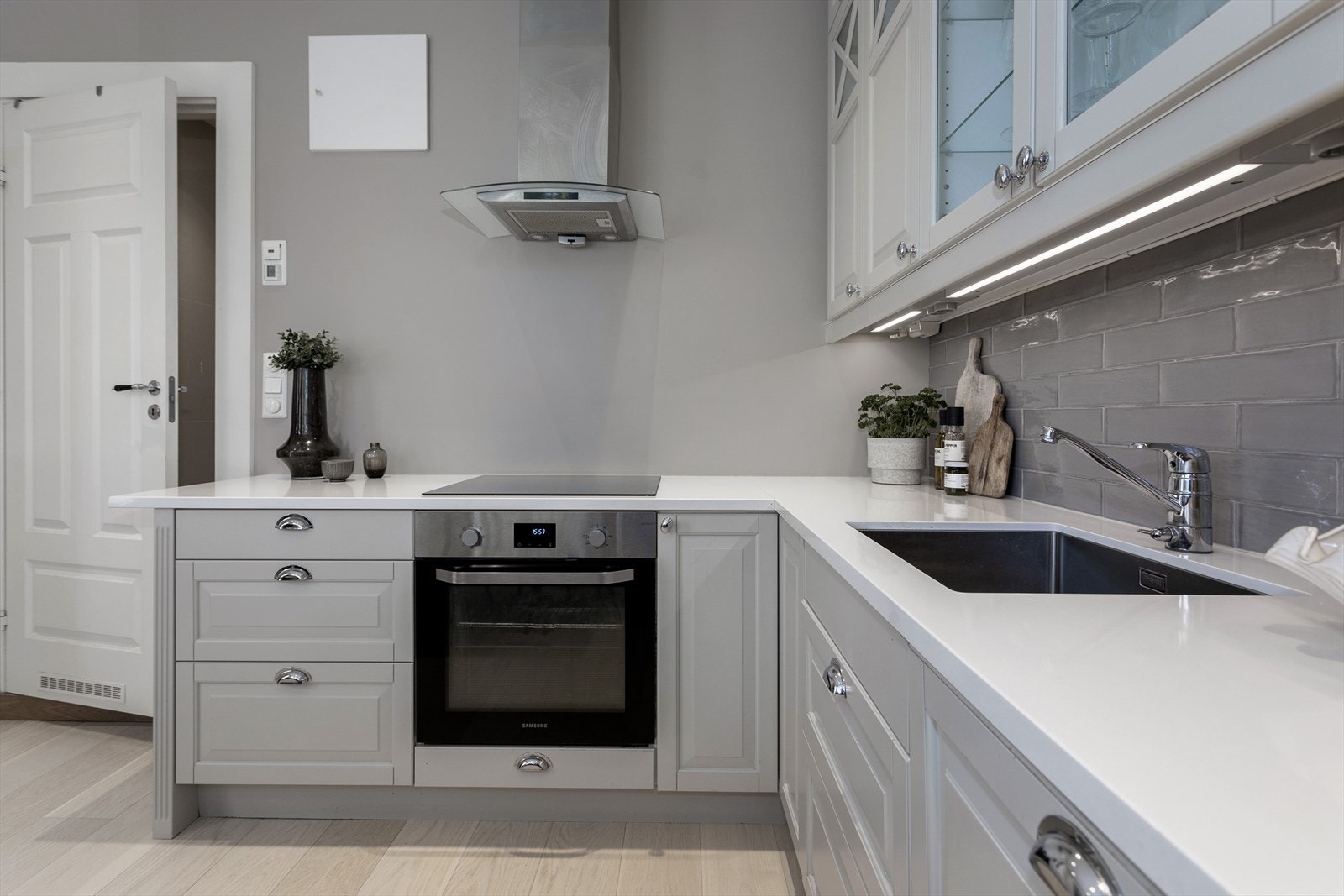 Moderne og stilren kjøkkeninnredning fra Epoq med integrerte hvitevarer, samt benkeplate i solid komposittstein Galleribilde