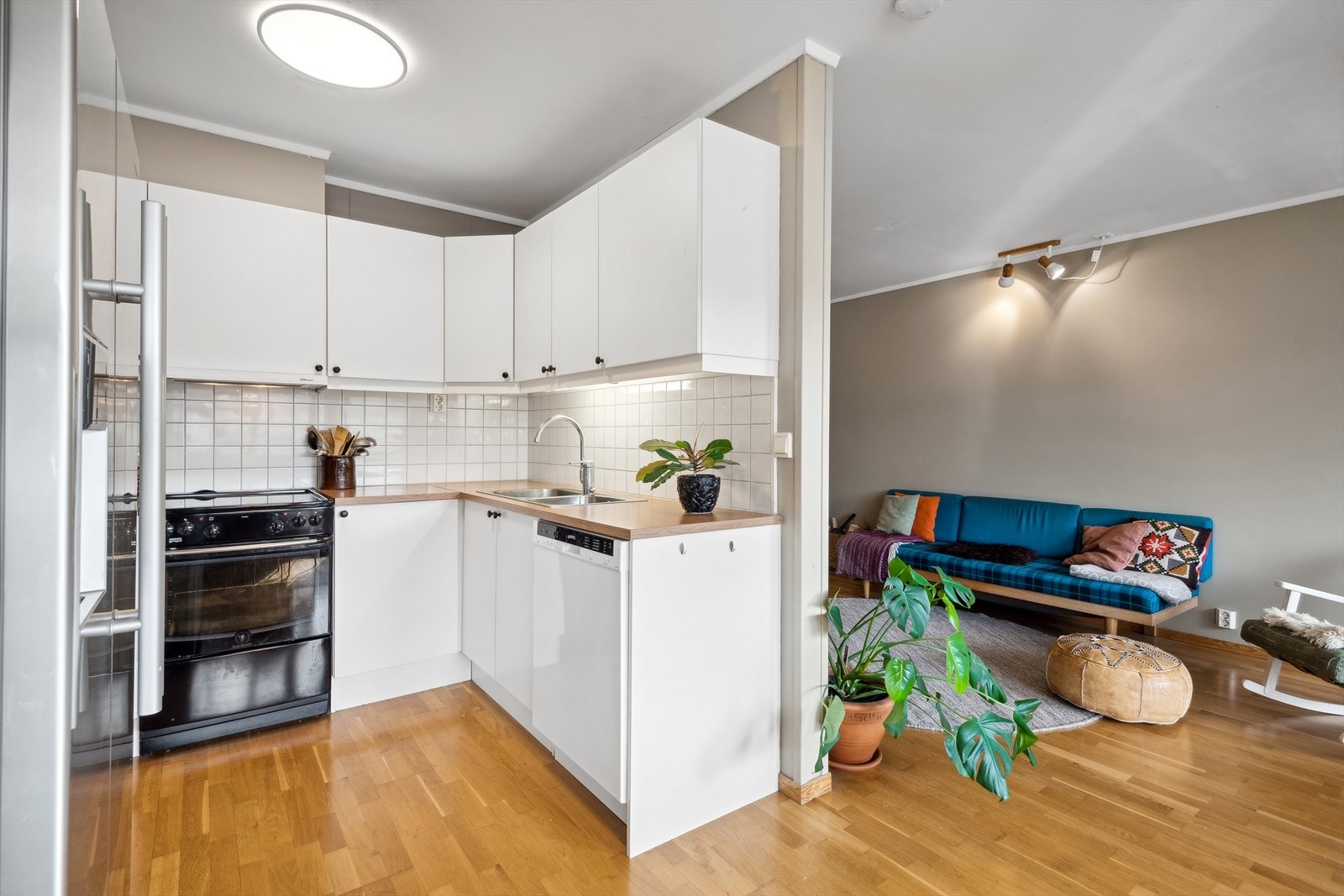 Denne løsningen mellom kjøkken og stue skaper en fin overgang som inviterer til både matlaging og sosialt samvær. Galleribilde