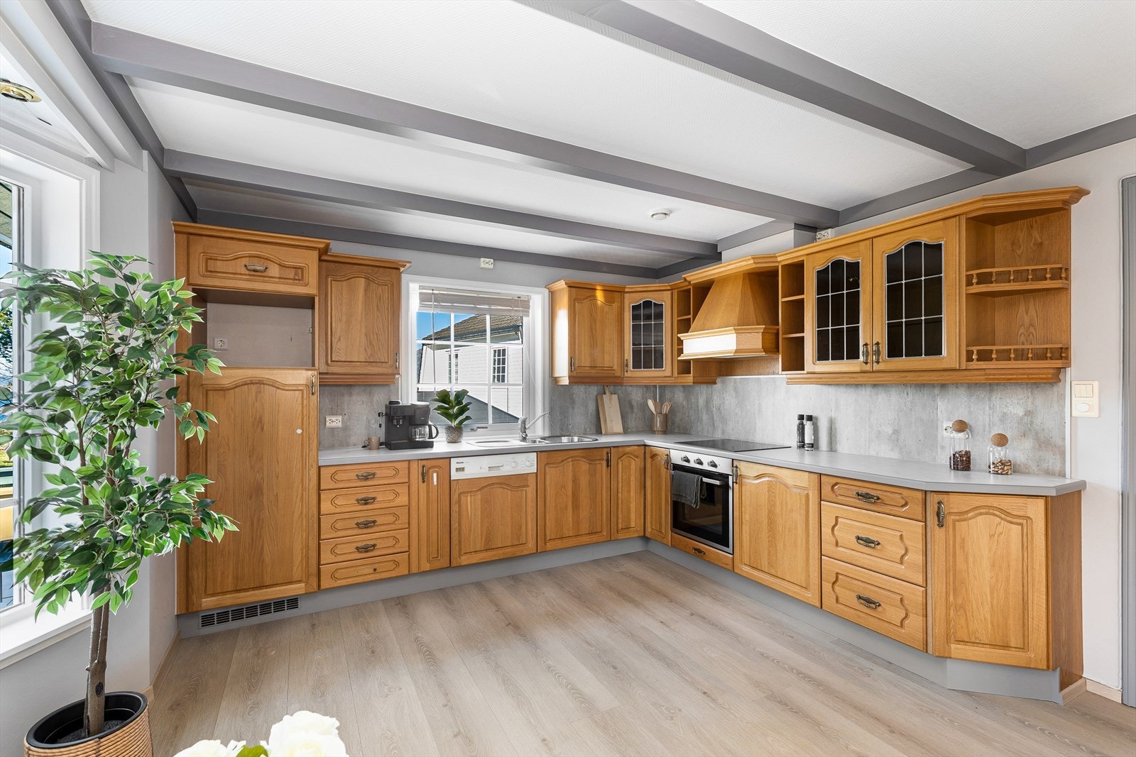 Stort kjøkken med laminat benkeplate , nedfelt stålvask og ny platetopp, ny komfyr, oppvaskmaskin og integrert kjøleskap. Galleribilde