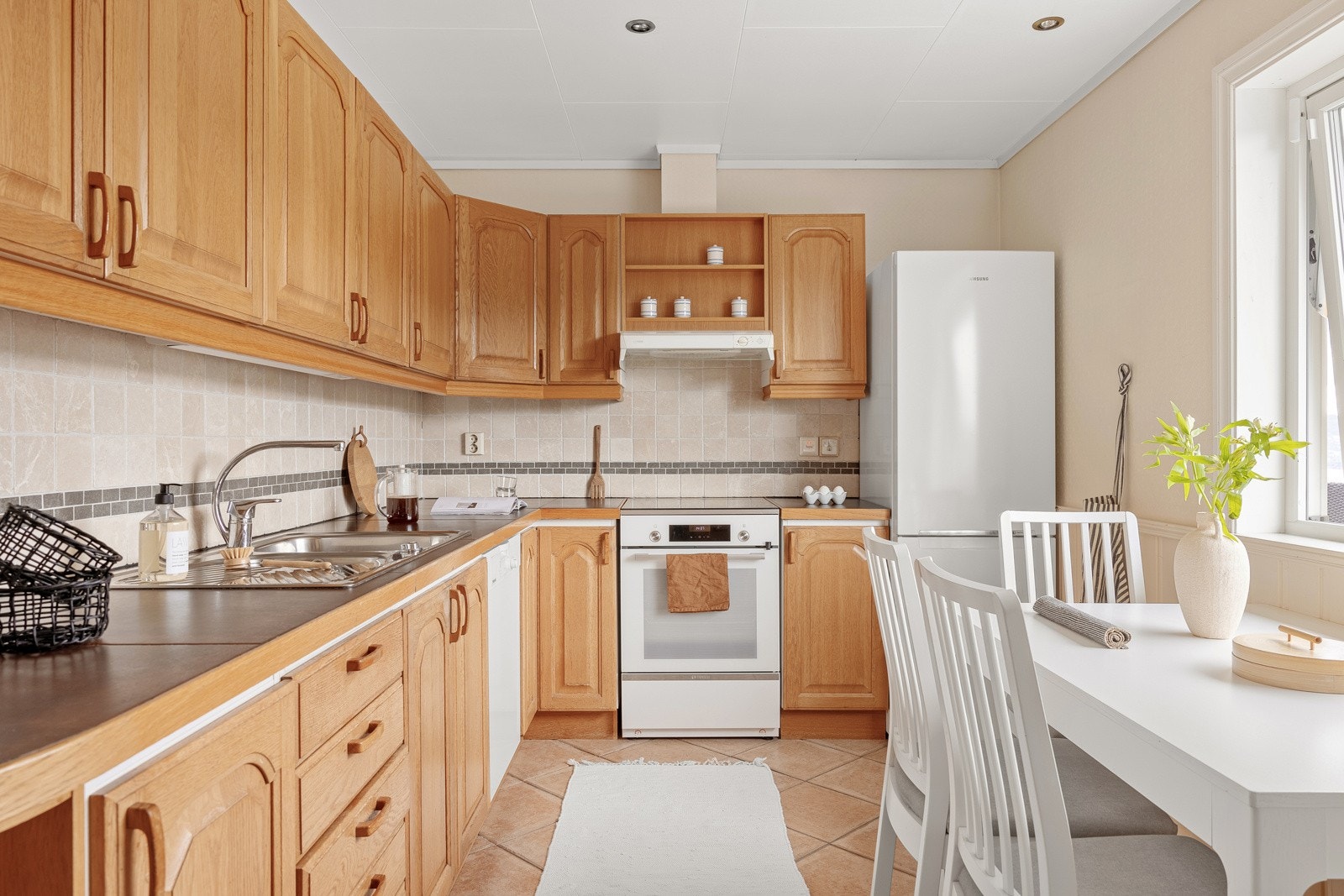 Kjøkkenet er av god kvalitet og er innredet med profilerte fronter, benkeplater belagt med fliser og nedfelt oppvaskkum. Galleribilde