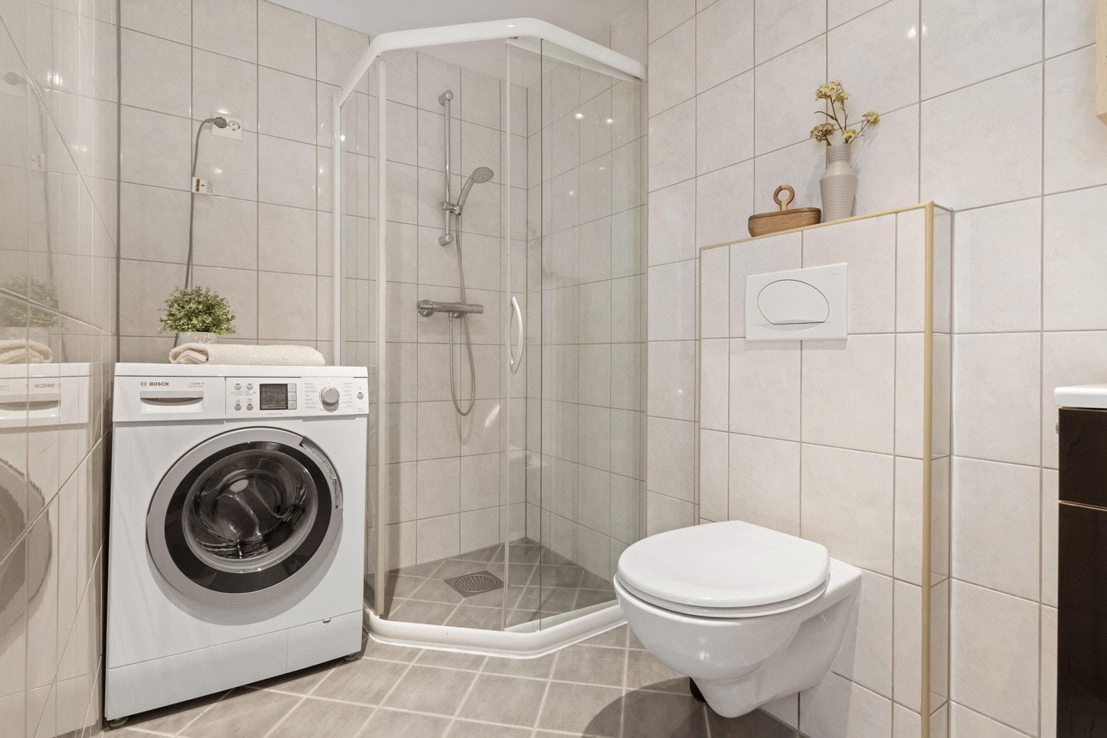 Badet er innredet med gulvvarme, downlights og fliser i ulike grånyanser. Galleribilde