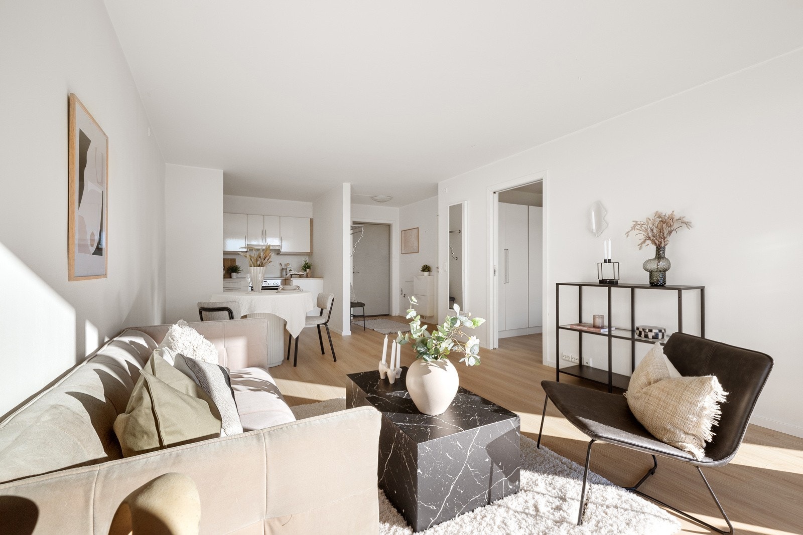 Innenfor entreen danner stuen og kjøkkenet et åpent allrom, der veggen i front består av en skyvedør i glass til den solrike terrassen. Galleribilde