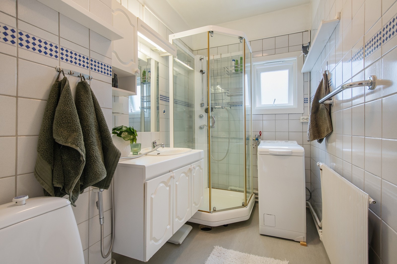 Badet er i opprinnelig stand fra byggeår og ligger med adkomst fra gangen. Badet er utstyrt med dusjkabinett, servant med skapinnredning, opplegg for vaskemaskin og toalett. Galleribilde