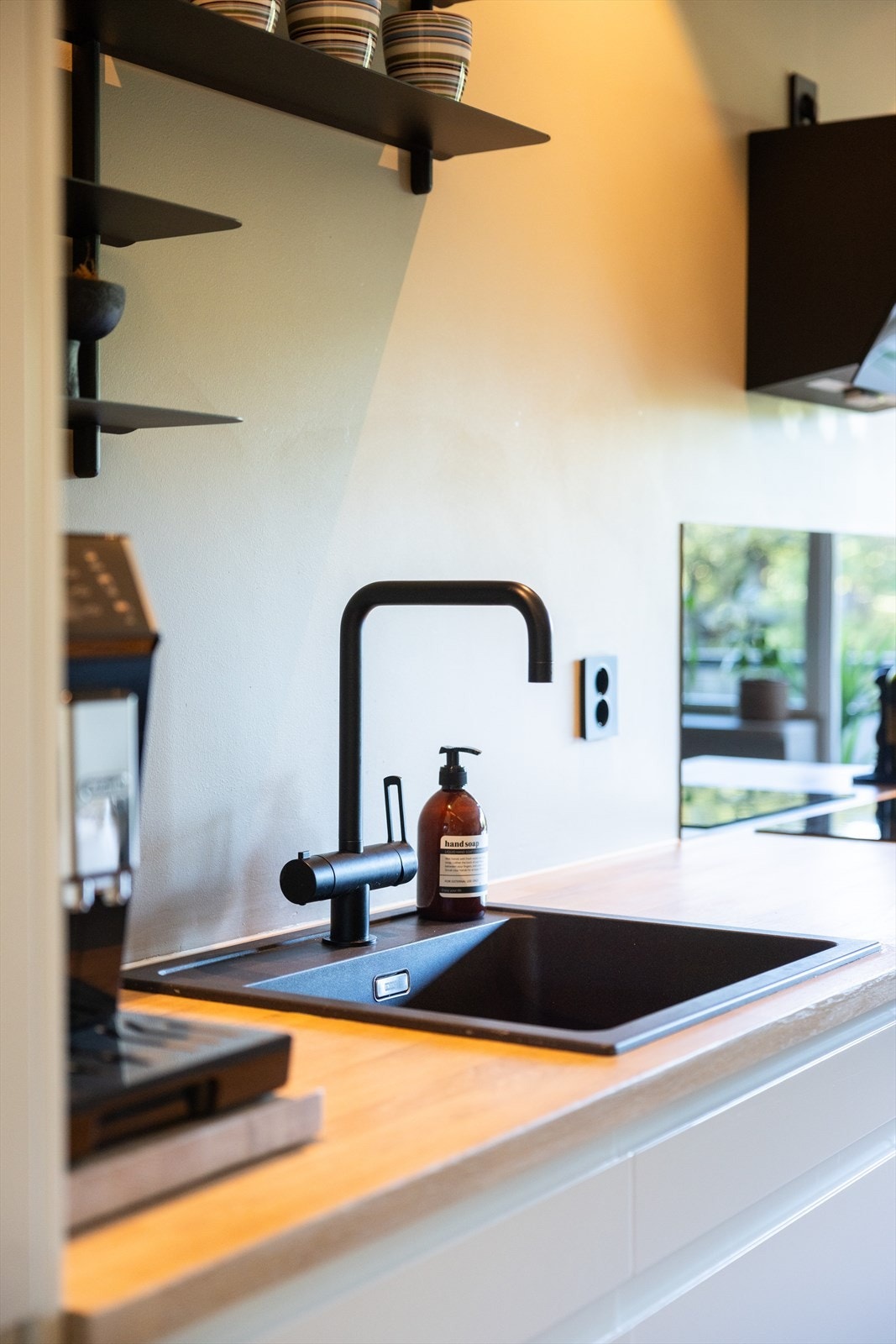 Stilrene sorte detaljer på kjøkkenet går igjen i hvitevarer og innredning. Galleribilde