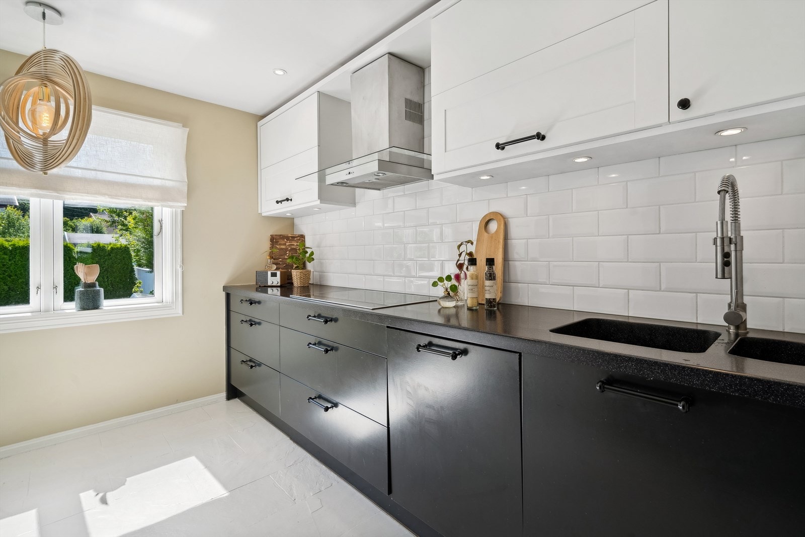 Gulvet og veggen mellom kjøkkenskapene er flisbelagt. Både himling og underskap er utstyrt med downlights. Galleribilde