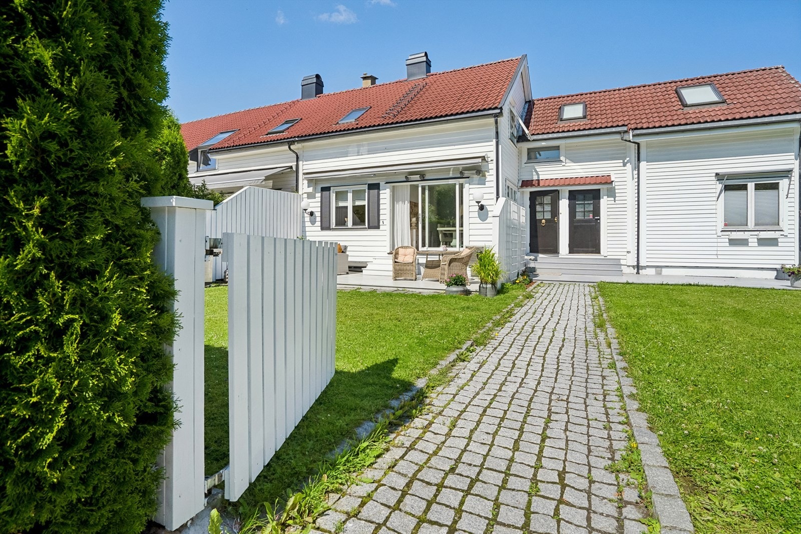 Oppgangen til boligen er belagt med brostein og går gjennom en idyllisk, grønn plen. Galleribilde