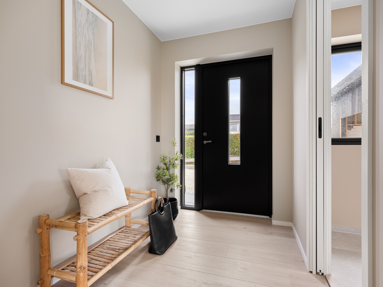 Inngangspartiet har lyse vegger og et vindu som slipper inn mye lys, noe som gir en følelse av åpenhet. Galleribilde