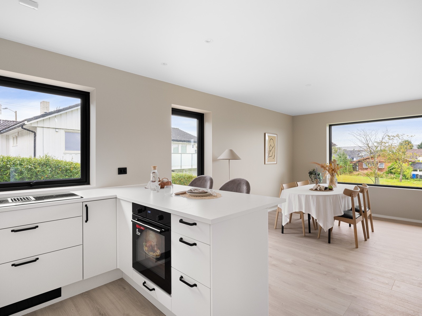 Dagslyset som strømmer inn gjennom vinduene bidrar til et lyst og trivelig rom, noe som gjør matlagingen til en fornøyelse. Galleribilde