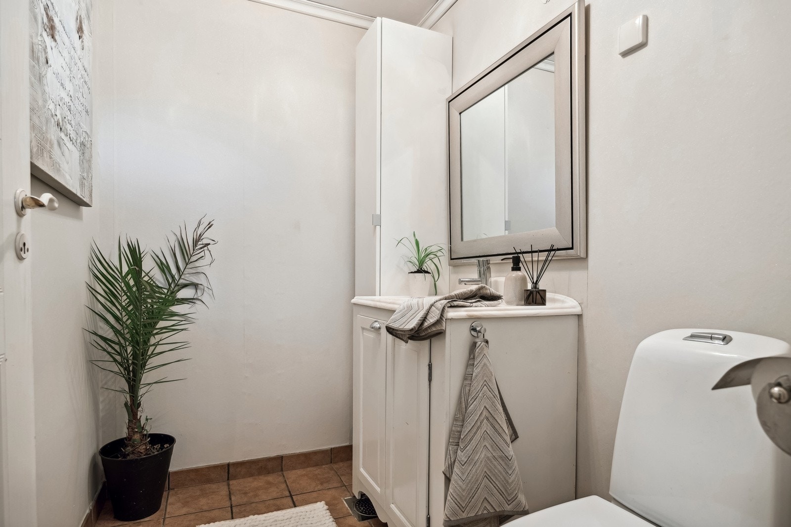 Toalettrom i 1. etasje med flislagt gulv og tapetserte veggflater. Galleribilde