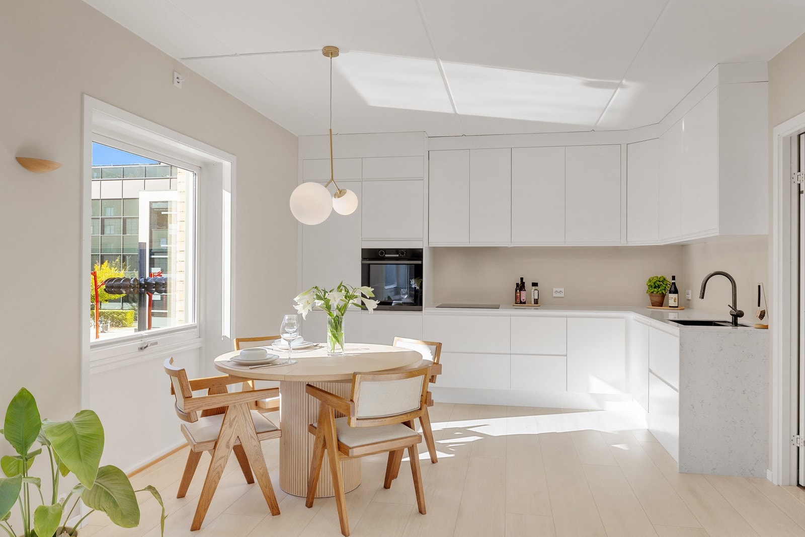 Stilrent kjøkken fra 2022 med glatte fronter i matt hvit utførelse. Galleribilde