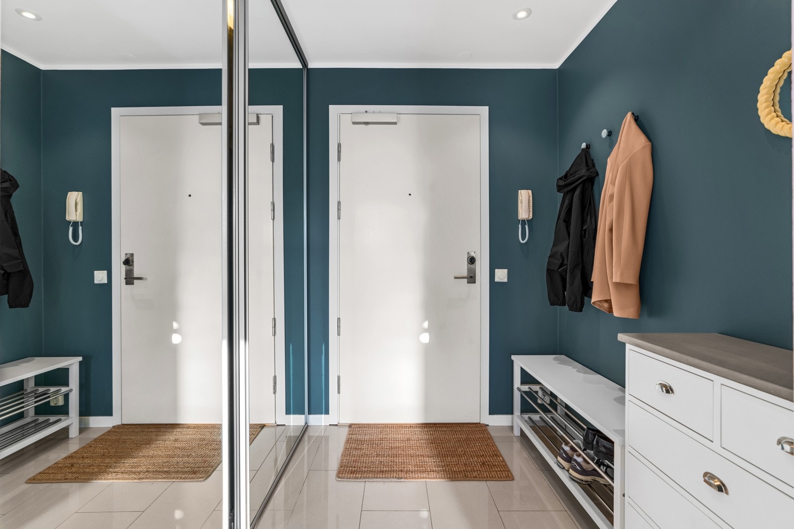 Leilighetens entré oppleves som praktisk og er innredet med stor skyvedørsgarderobe Galleribilde