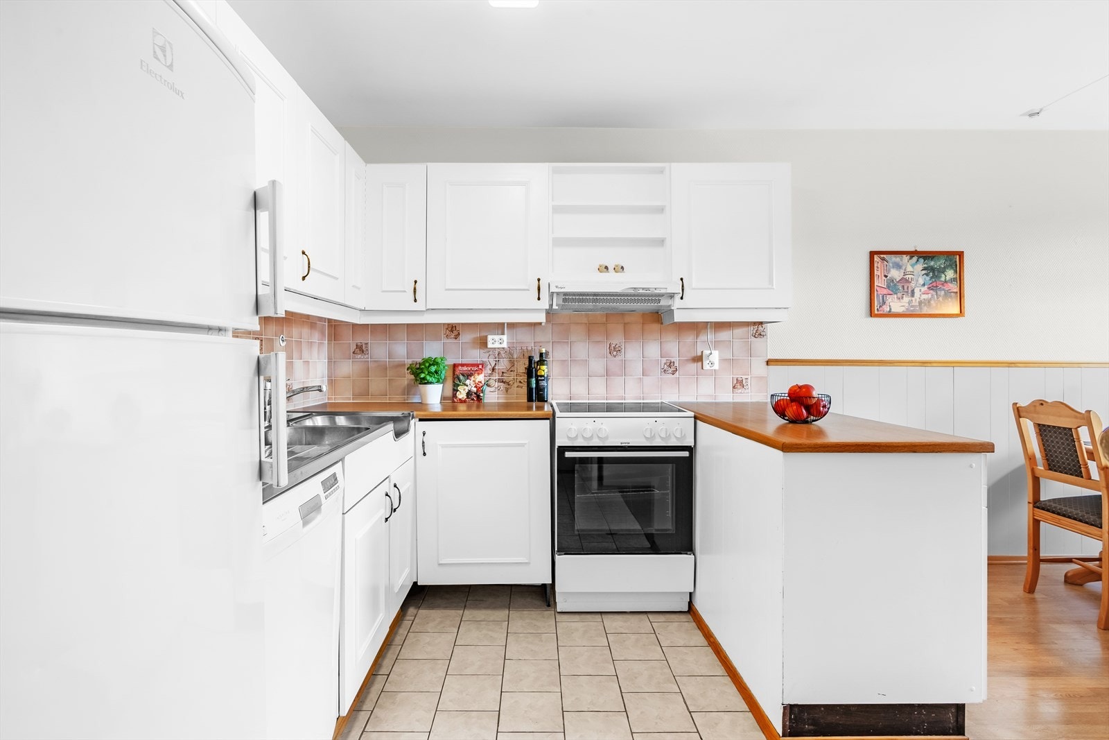 Kjøkkenet er utstyrt med komfyr med platetopp, oppvaskmaskin i egen nisje og frittstående kjøl/fryseskap. Galleribilde