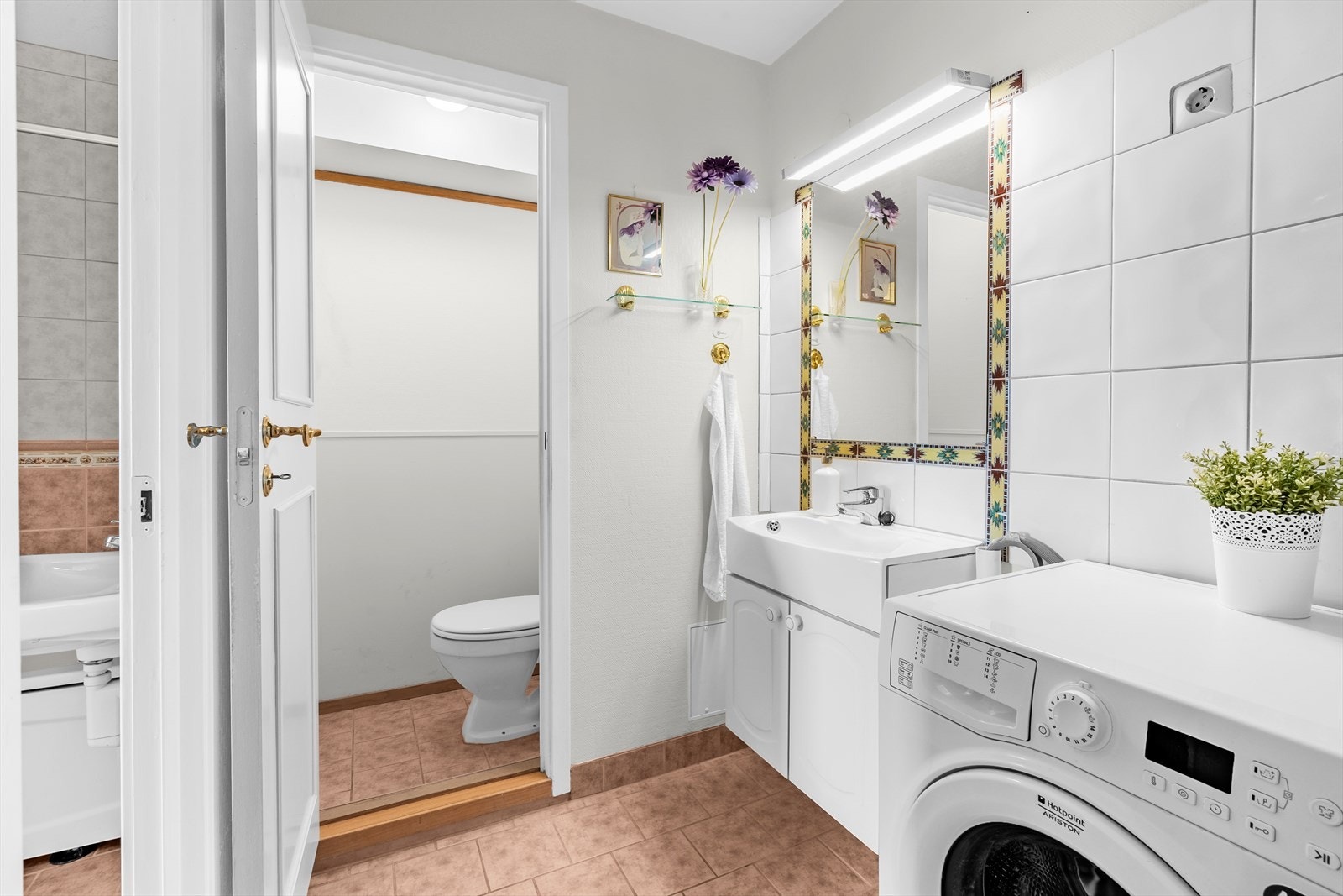 Eldre våtrom med behov for modernisering. Våtrommet er tredelt med vaskerom, bad og toalett med egen dør. Vaskeromsdelen har innredning med glatte, folierte fronter og heldekkende servant. Speil og lysarmatur på vegg over servant. Opplegg for vaskemaskin. Galleribilde