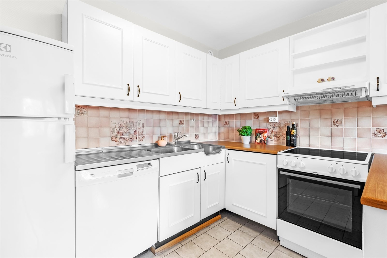 Rommet har behov for modernisering. Kjøkkeninnredningen består av profilerte, malte fronter, laminat benkeplate og heldekkende benkeplate i rustfritt stål. Galleribilde