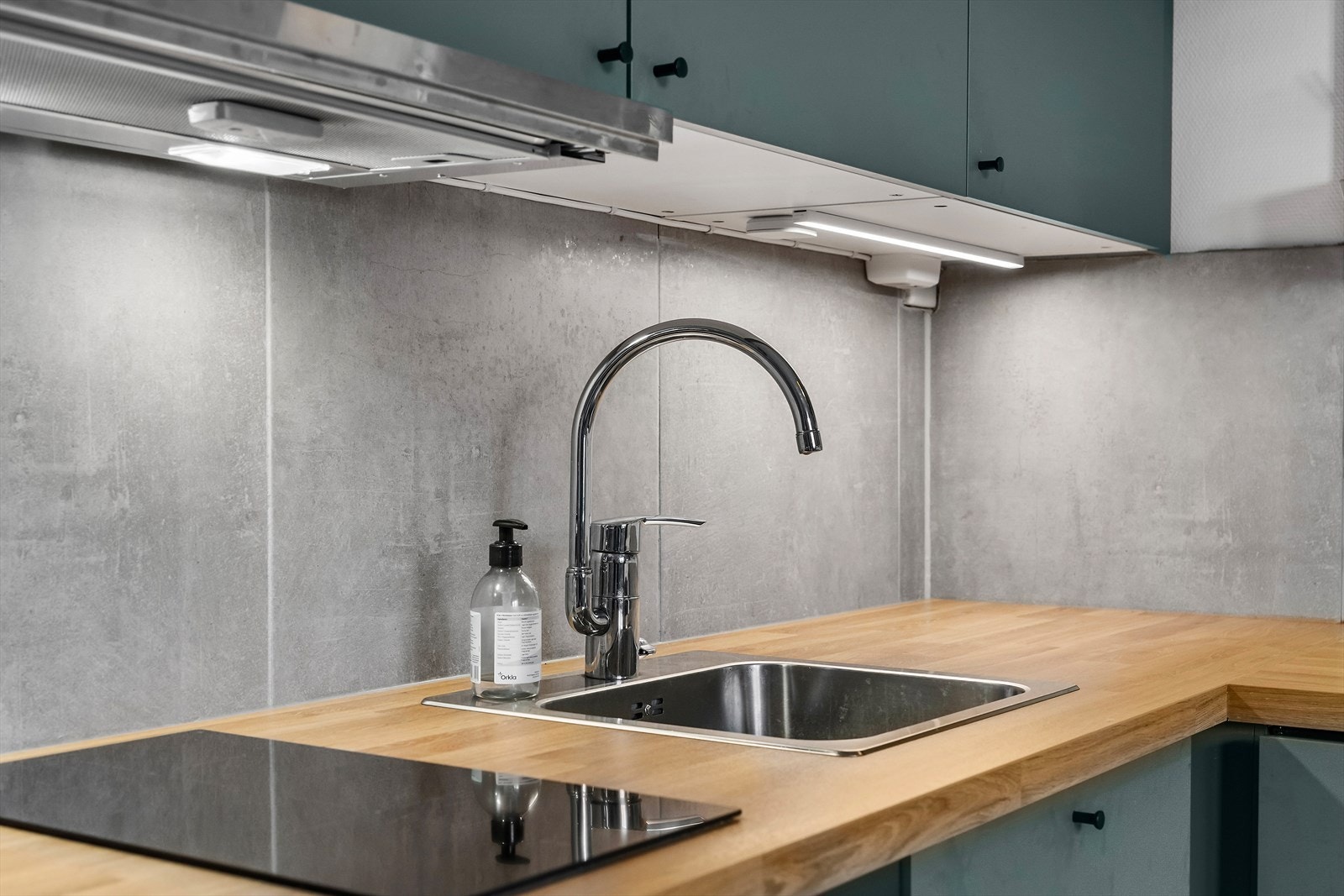 Kjøkkeninnredning med glatte laminerte fronter, laminert benkeplate som har overliggende oppvaskkum med ettgreps blandebatteri Galleribilde