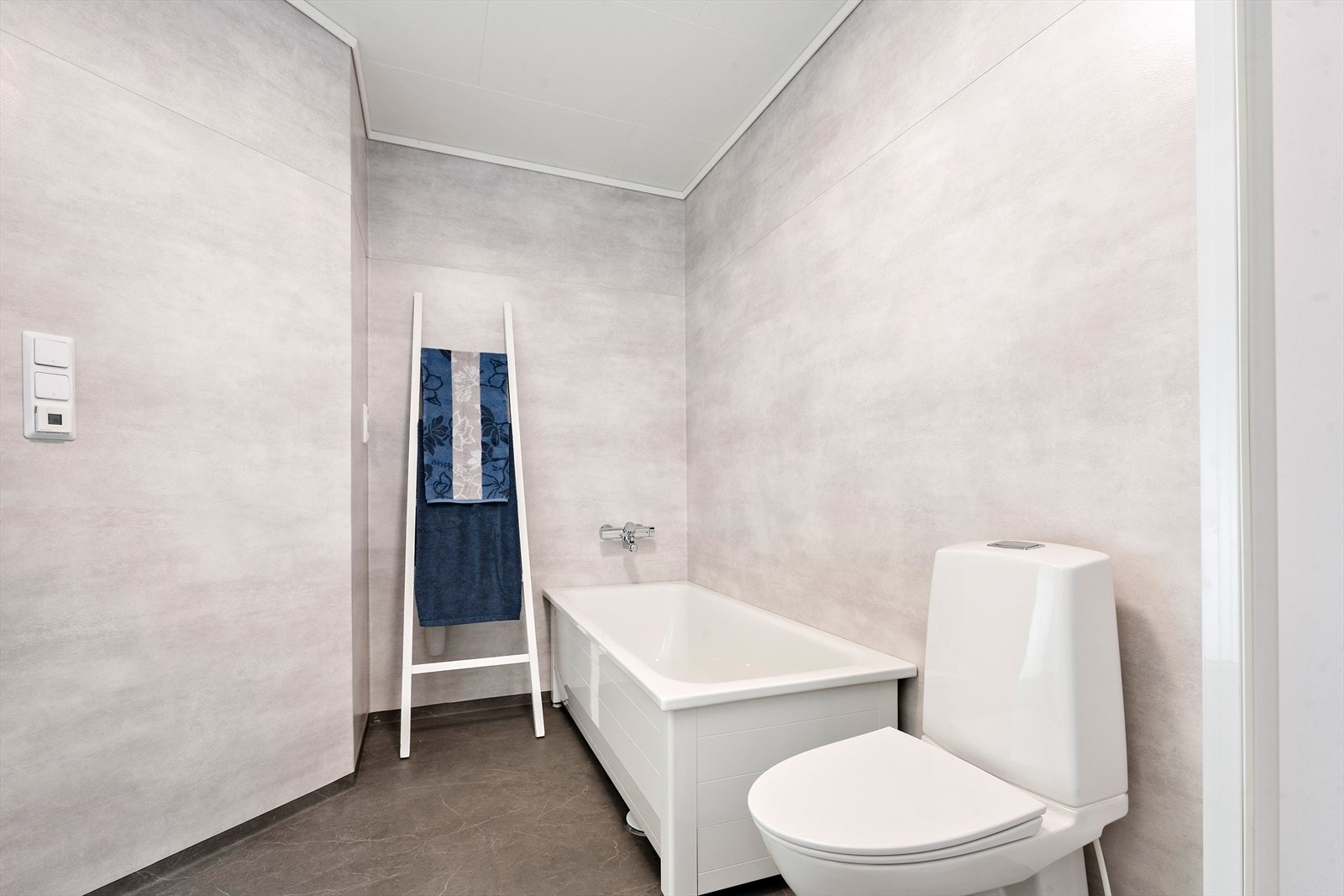 Badet er innredet med toalett, innredning med servant, dusjkabinett og badekar. Galleribilde